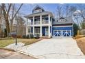 Beautiful two-story blue house with double porch, detailed garage doors, and landscaped front yard at 1721 Streamview Se Dr, Atlanta, GA 30316