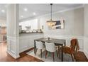 Elegant dining area with chic chandelier, wainscoting, and an open view to the kitchen at 100 Brickworks Ne Cir # 104, Atlanta, GA 30307