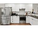 Modern kitchen showcasing stainless steel appliances, white cabinetry, and sleek black countertops at 100 Brickworks Ne Cir # 104, Atlanta, GA 30307