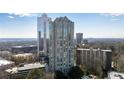 An exterior shows a tall modern building with reflective glass windows and surrounding trees at 2870 Pharr Court South Nw # 2002, Atlanta, GA 30305