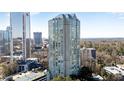 An exterior view shows a tall modern building with reflective glass windows and surrounding trees at 2870 Pharr Court South Nw # 2002, Atlanta, GA 30305