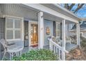 Inviting front porch with seating area, classic columns, and beautiful wood door at 959 Glen Arden Ne Way, Atlanta, GA 30306