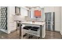 Well-lit kitchen featuring stainless steel appliances, an island with seating, and geometric tile backsplash at 1145 Kirkwood Se Ave # 4, Atlanta, GA 30316