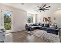 Spacious living room with large windows, dark leather sectional, ceiling fan, and stylish decor for a modern feel at 1145 Kirkwood Se Ave # 4, Atlanta, GA 30316