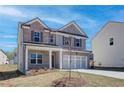 Two-story home featuring a brick and gray facade, well-manicured lawn, and a two-car garage at 706 Bristol Dr, Loganville, GA 30052