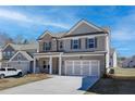 Two-story home featuring a brick and gray facade, well-manicured lawn, and a two-car garage at 706 Bristol Dr, Loganville, GA 30052