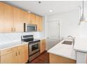 Modern kitchen with stainless steel appliances, natural wood cabinets, and white countertops at 361 17Th Nw St # 922, Atlanta, GA 30363
