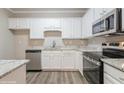 Modern kitchen with stainless steel appliances, granite countertops, and white cabinets at 323 Sweetshrub Dr, Austell, GA 30168