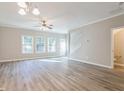 Bright living room with wood-look flooring, large windows, and a view of the staircase at 323 Sweetshrub Dr, Austell, GA 30168