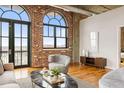 Spacious living room with exposed brick walls, hardwood floors, and a modern design at 3235 Roswell Ne Rd # 917, Atlanta, GA 30305