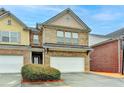 Charming brick townhome with a two-car garage and well-maintained front yard at 3981 Isaac Ct, Lilburn, GA 30047