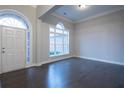 Bright living room with dark hardwood floors, front door, and many windows at 5715 Catalpa Ct, Cumming, GA 30040