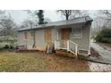 Back view of single-story home with boarded windows, in need of repairs or renovations at 1969 Oak Valley Rd, Decatur, GA 30035