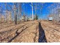 Spacious backyard features mature trees, lush ground cover, and a charming home nestled in a serene setting at 2370 Huckleberry Ln, Lithia Springs, GA 30122