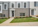 Close-up exterior shot features townhouse with stylish entryway, black door, and well-kept lawn at 3165 Dogwood Dr # 108, Hapeville, GA 30354