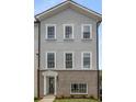 Newly built two-story townhome featuring gray siding, a brick facade, and white-trimmed windows and doorway at 3165 Dogwood Dr # 108, Hapeville, GA 30354