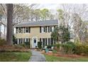 Inviting two-story home featuring black shutters, a light blue door, and a beautifully landscaped front yard at 566 Wagon Wheel Climb, Lawrenceville, GA 30044