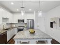 Stylish kitchen featuring stainless steel appliances, granite countertops, white cabinetry, and a center island at 840 United Se Ave # 411, Atlanta, GA 30312