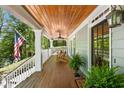 Covered porch with wood floors, wood ceiling, wood chairs and an American flag at 135 River Ne Lndg, Sandy Springs, GA 30350