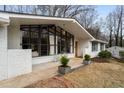 The home's exterior shows painted white brick, and a large picture window providing great natural light at 665 Lake Charles Way, Roswell, GA 30075