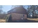 Angle view of the back exterior of the home with brick facade and siding. A door allows access to the backyard at 3747 Southland Ct, Atlanta, GA 30344
