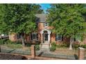 Traditional brick home with mature trees, black shutters, and a wrought iron fence at 6700 Roswell Rd # 32C, Atlanta, GA 30328