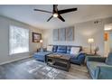 Cozy living room with a modern ceiling fan, gray walls, and a comfortable blue sectional sofa at 6700 Roswell Rd # 32C, Atlanta, GA 30328
