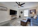 Bright living room with a large TV, modern ceiling fan, and a comfortable blue sectional sofa at 6700 Roswell Rd # 32C, Atlanta, GA 30328