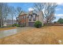 Traditional two-story home with a two-car garage, brick facade, and well-manicured lawn and landscape at 2295 Hemrick Rd, Cumming, GA 30041