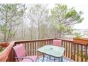 Relaxing outdoor deck area with table, chairs, and a view of the surrounding trees at 3068 Cedar Glade Ln, Buford, GA 30519