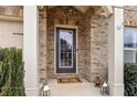 Close-up of the home's entrance with decorative lanterns, and a brick surround, offering a welcoming and stylish entryway at 4240 Hunters Walk Way, Cumming, GA 30028