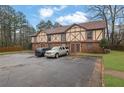 Two-story townhome exterior featuring a Tudor style, parking spaces, and an established lawn at 3236 Abbeywood Dr, Decatur, GA 30034