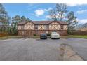Traditional-style townhome exterior with parking, showcasing Tudor architectural details and mature trees at 3236 Abbeywood Dr, Decatur, GA 30034