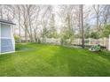 A manicured backyard featuring lush artificial turf, a charming white picket fence, and neat landscaping at 1195 Cameron Ne Ct, Atlanta, GA 30306