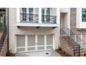 Townhome featuring a front-entry garage, balcony, and brick stairway with iron railings at 275 Briscoe Way # 3, Alpharetta, GA 30009