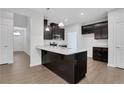 Modern kitchen featuring dark cabinets, granite countertops, stainless steel appliances, and a center island at 701 Bickmore Dr, Mcdonough, GA 30253