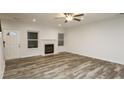 Bright living room showcasing a fireplace, new floors, and a ceiling fan at 6350 Akins Way, Cumming, GA 30041