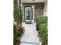 Welcoming front entrance featuring a black-framed door, stone accents, and manicured landscaping at 7248 Mountain Laurel Way, Stockbridge, GA 30281