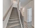 Carpeted staircase with modern railings leads to the upper levels of the home at 5473 Blossomwood Sw Trl, Mableton, GA 30126