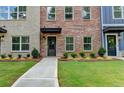 Close-up of a townhome front yard with landscaping leading to the front door at 5477 Blossomwood Sw Trl, Mableton, GA 30126