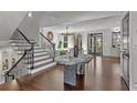 Grand foyer boasting a statement table, a striking staircase, and beautiful hardwood floors, adding a touch of sophistication at 620 Camp Ave, Roswell, GA 30075