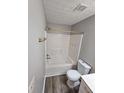The bathroom features a shower-tub combo with gold hardware and grey vinyl plank flooring at 475 Lakeside Cir, Covington, GA 30016