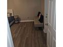 View of luxury vinyl plank flooring in the bedroom with a bench in the corner at 475 Lakeside Cir, Covington, GA 30016