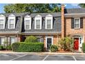 Charming townhome with brick facade, dormer windows, and manicured landscaping at 5 Spring Green Pl, Atlanta, GA 30318