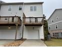 Back exterior view showing the wood decks and individual garages of the townhome at 5463 Blossomwood Sw Trl, Mableton, GA 30126