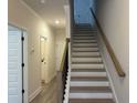 Interior view of the staircase with wooden handrail and gray flooring at 5463 Blossomwood Sw Trl, Mableton, GA 30126