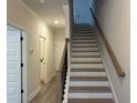 Bright staircase with hardwood treads and a modern handrail design at 5463 Blossomwood Sw Trl, Mableton, GA 30126