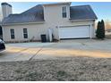 Rear exterior of home with attached two-car garage and a small covered doorway at 1507 Smithfield Dr, Mcdonough, GA 30252