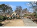 Spacious home with a long driveway and lovely, mature landscaping in the front yard at 4323 Lake Chimney Ne Ct, Roswell, GA 30075