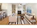 Bright living room featuring hardwood floors, fireplace, and a ceiling fan, staged with modern furniture at 2693 Avanti Way, Decatur, GA 30035